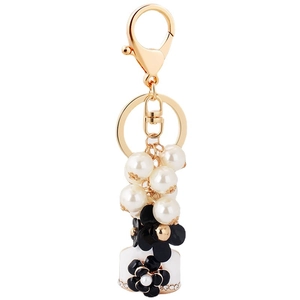 Elegante portachiavi con perle e ciondolo a forma di camelia in smalto nero