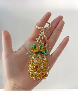Detail shot of golden pineapple keychain encrusted with yellow and green crystals