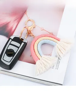 Handmade bohemian rainbow keychain with pink tassels and rose gold hook on a magazine