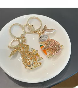 Detail of two cartoon rabbit keychains with gold hearts and sparkling rhinestones