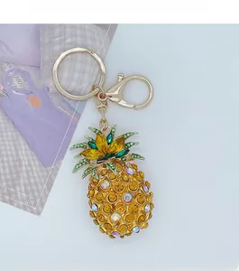 Close-up of sparkling pineapple keychain featuring colorful crystals and golden lobster clasp