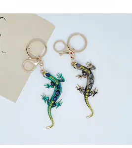 Detailed close-up of crystal-encrusted lizard keychains with polished gold hardware