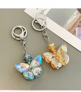 Detailed macro view of two crystal butterfly keychains in blue and champagne gold finishes