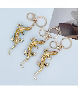 Detailed view of three gold-plated lizard keychains with crystals and lobster clasps
