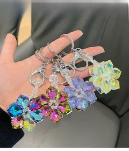 Detail of four colorful crystal sunflower keychains with faceted petals and silver clips