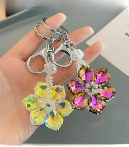 Detail of crystal snowflake keychains in yellow and pink hues with metallic clasps