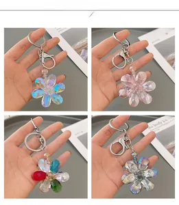 Detailed macro view of crystal five-petal flower keychains in four iridescent colors
