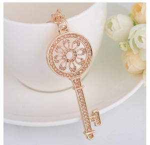 Détail du pendentif clé en or rose avec strass champagne sur une tasse en céramique