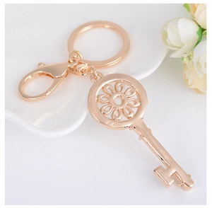 Vue détaillée du porte-clés doré avec tête de fleur évidée et strass brillants