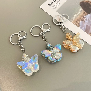 Handmade butterfly crystal keychain in iridescent clear, blue-green, and champagne gold