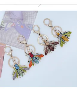 Detailed display of four colorful rhinestone bee keychains with lobster clasps and gold rings