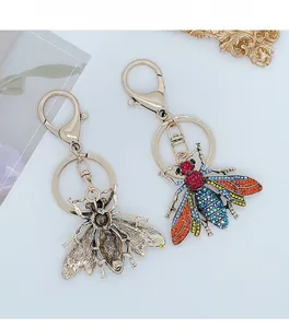 Close-up of alloy bee keychains with colorful rhinestones and vintage gold finish