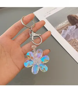 Close-up of iridescent crystal flower keychain with silver ring for bags and keys