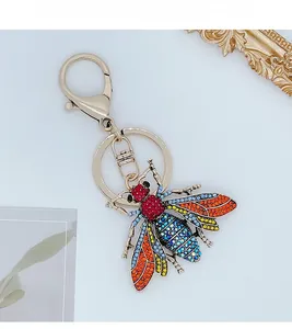 Macro detail of bee keychain with colorful rhinestones on a gold alloy metal base