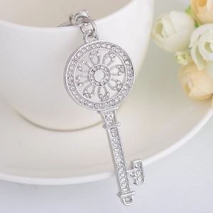Pendentif clé argenté étincelant avec strass sur une tasse pour sac ou porte-clés