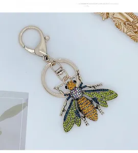 Detail of bee keychain pendant with colorful rhinestones on a gold metal frame