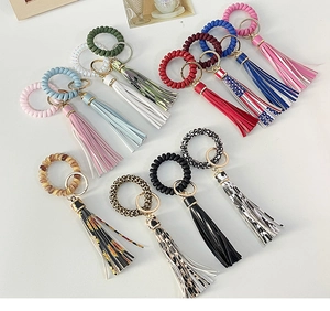 Detail view of colorful spiral phone cord bracelets with leopard and floral tassel charms