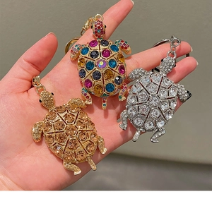 Dettaglio di tre portachiavi a forma di tartaruga con strass colorati e cristalli lucidi