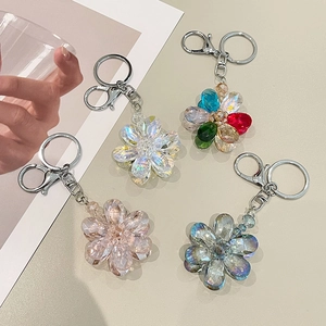 Floral crystal bead keychains in four colors with silver metal clasp on beige background