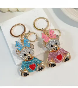 Gros plan de porte-clés ours en strass brillants bleu et rose avec détails de nœuds