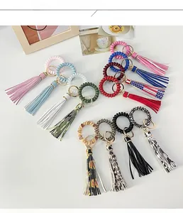 Top view display of assorted telephone wire keychain bracelets with leopard tassels