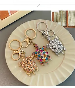 Dettaglio di portachiavi a forma di tartaruga con cristalli colorati in oro e argento