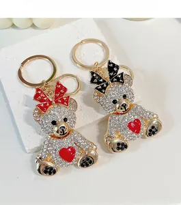 Détail du porte-clés ourson en cristal avec cœur rouge et nœuds décoratifs élégants