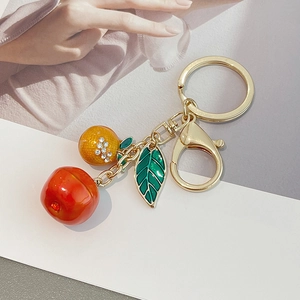 Fruit themed keychain with orange and persimmon pendants on gold ring and lobster clasp