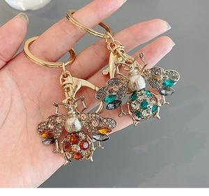 Detailed macro of crystal bee keychains with rhinestones and golden metal hardware
