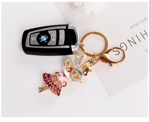 Detailed macro view of a golden ballet girl keychain with sparkling purple rhinestones