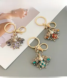 Close-up of cute honey bee keychains with colorful rhinestones in three vibrant colors
