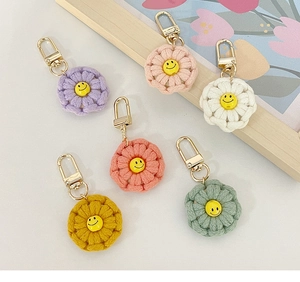 Close-up of colorful handmade crochet flower keychains with smiley face charms and gold clips