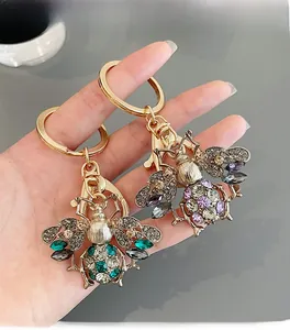 Detailed macro view of rhinestone-encrusted bee keychains with sparkling gemstone wings
