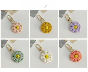 Macro view of six colorful handmade crochet flower keychains with yellow smiley face buttons