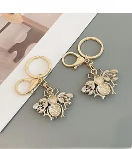 Detail of gold bee keychain with rhinestone wings and dual-purpose brooch pin clip