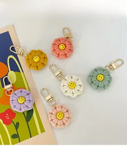 Detail showing six handmade crochet flower keychains with smiley faces and gold lobster clasps
