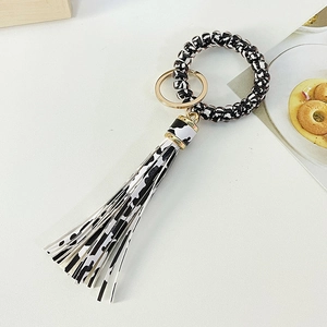 Phone cord wristlet keychain with cow print pattern and matching faux leather tassel
