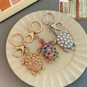 Portachiavi a forma di tartaruga con strass colorati in oro e argento su piatto