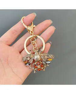 Detailed close-up of a sparkling bee keychain with multicolored rhinestones and golden metal