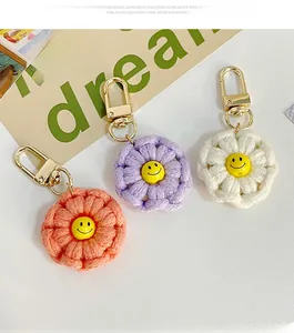 Close-up of handmade crochet flower keychains with smiley faces and golden metal lobster clasps