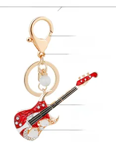Détail du porte-clés guitare électrique rouge et blanc orné de strass brillants