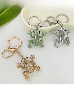 Detailed macro view of three frog keychains in green, silver, and gold with crystal rhinestones