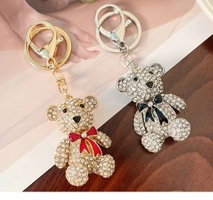 Close-up of sparkling rhinestone bear keychains with elegant red and black bow details