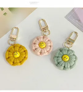Detail of handmade crochet flower keychains with smiley faces in three pastel colors