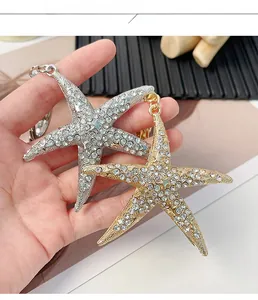 Vue détaillée de porte-clés étoile de mer en or et argent avec des strass étincelants