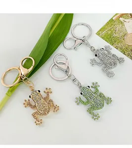 Detailed macro view of three crystal-encrusted frog keychains in gold and silver finishes