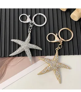 Gros plan de porte-clés étoiles de mer sertis de strass brillants en finitions or et argent
