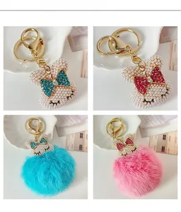 Dettaglio portachiavi a forma di coniglio in perle intrecciate con strass e pompon