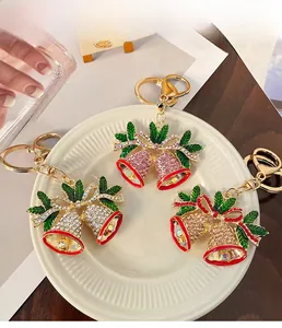 Detailed view of colorful rhinestone Christmas bell keychains with enamel leaf accents