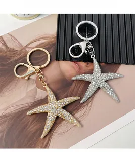 Détail de porte-clés étoile de mer ornés de strass en cristal sur finitions or et argent